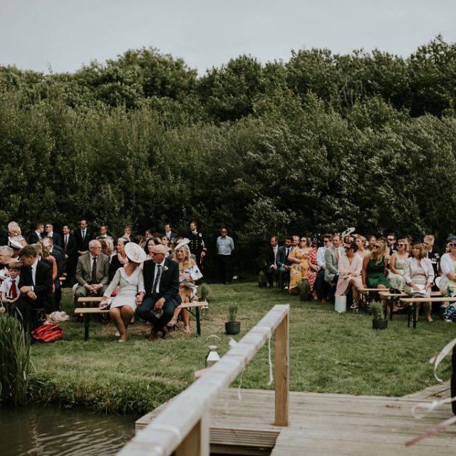 Guests seated for lake ceremony outside at Trevibban Mill wedding venue in cornwall