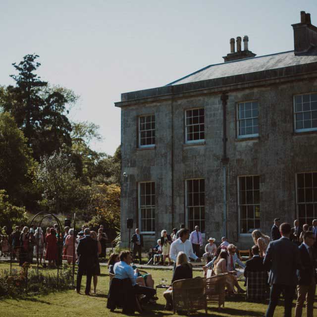 Guests having drinks on the lawns at a wedding at Enys House, Cornwall