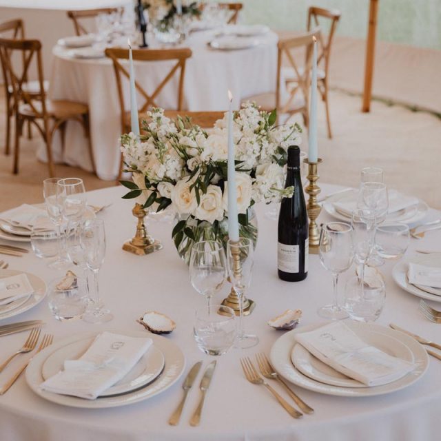 Small circular table set ready for guests at the wedding breakfast. This wedding in Cornwall was planned by Jenny Wren - wedding planner.