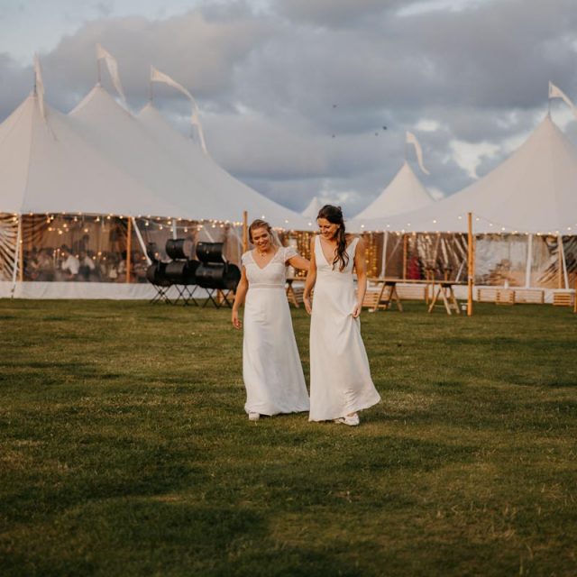 Emma and Annie walking away from their wedding gazebo in Cornwall. This Cornwall Wedding was planned by Jenny Wren Wedding Planner.